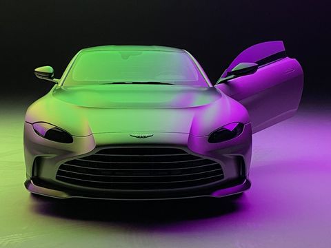 An Aston Martin Vantage lit in green and violet in the studio