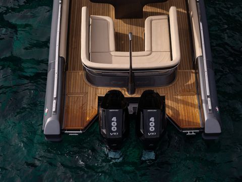 A luxury tender seen from directly above, its teak deck against dark green water